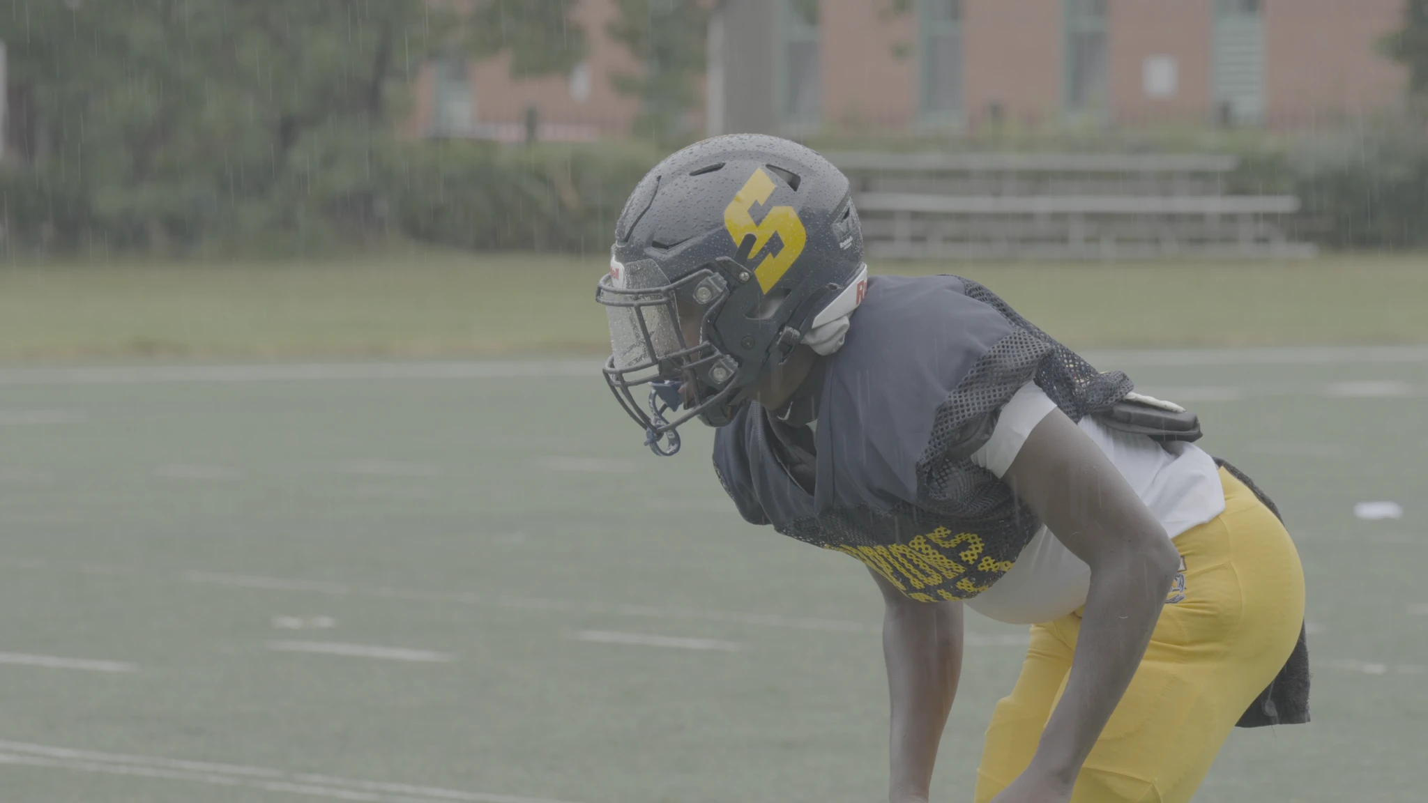 A football player in a helmet, flat camera log, before grading.